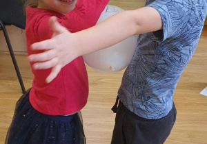 Hania i Jaś tańczą z balonem.